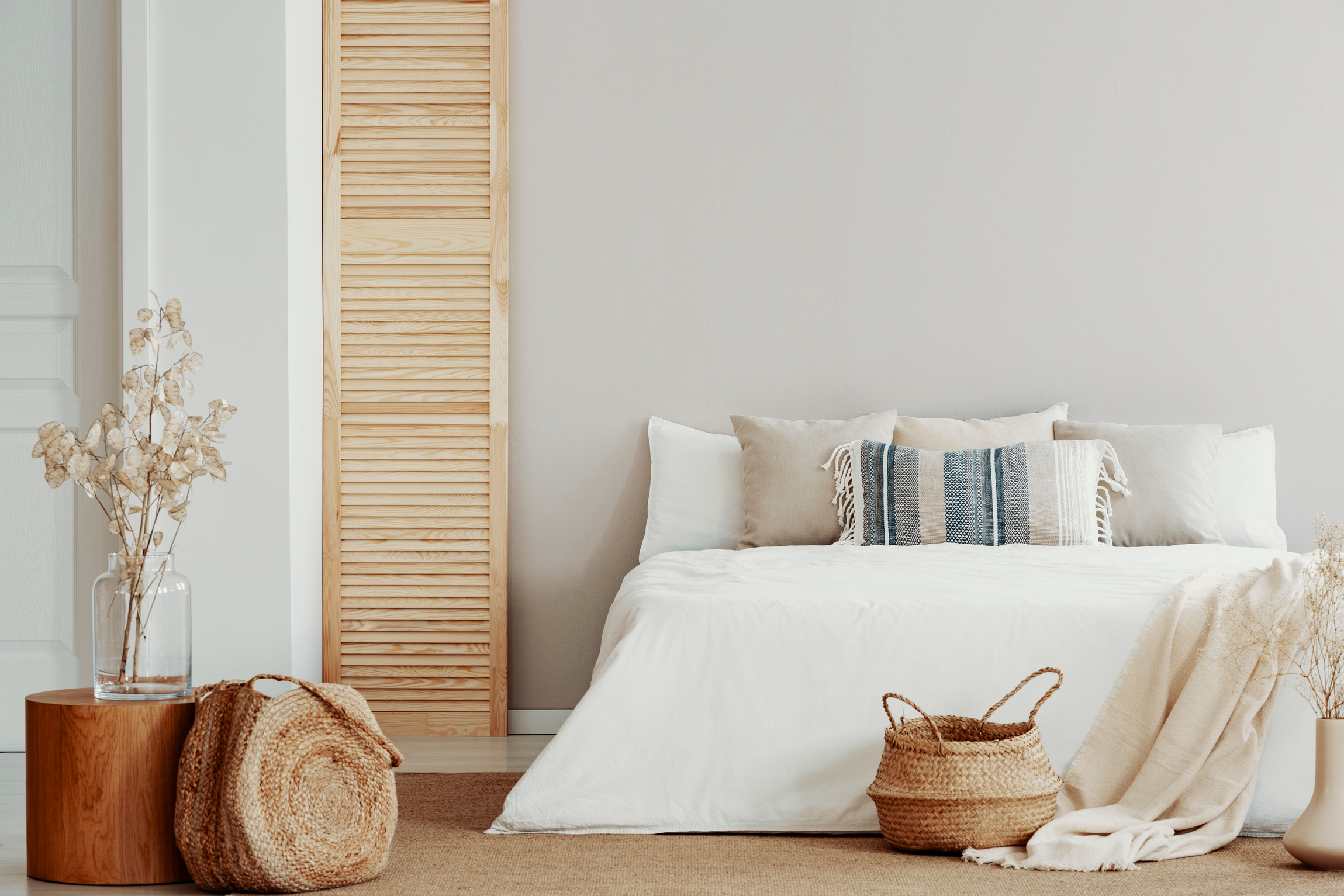 Copy space on white empty wall of natural bright bedroom with natural accents